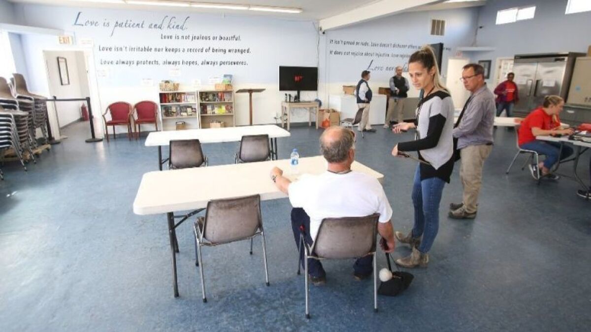 A client sits in the multipurpose room at Costa Mesa’s homeless shelter at Lighthouse Church of the Nazarene at 1885 Anaheim Ave. in the city’s Westside. The facility opened in April.