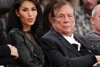 In this photo taken on Friday, Oct. 25, 2013, Los Angeles Clippers owner Donald Sterling, center, and V. Stiviano, right, watch the Clippers play the Sacramento Kings during the first half of an NBA basketball game, in Los Angeles. The NBA is investigating a report of an audio recording in which a man purported to be Sterling makes racist remarks while speaking to Stiviano. NBA spokesman Mike Bass said in a statement Saturday, April 26, 2014, that the league is in the process of authenticating the validity of the recording posted on TMZ's website. Bass called the comments "disturbing and offensive." (AP Photo/Mark J. Terrill) ** Usable by LA and DC Only **