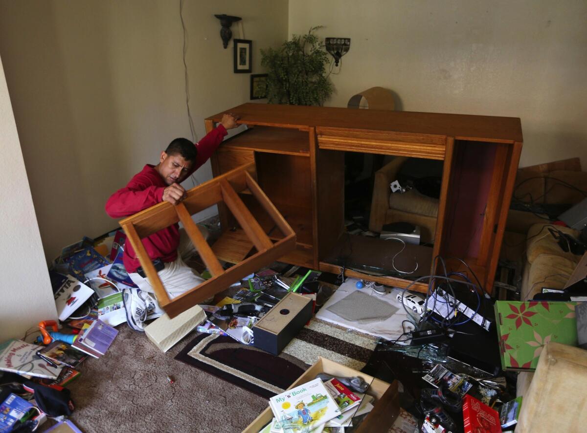 Jamie Gudino cleans up the damage from an early morning earthquake in Napa, Calif., on Aug. 24, 2014, (Rich Pedroncelli / Associated Press)
