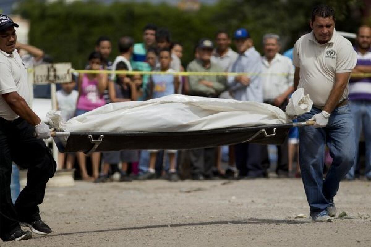 Forensic investigators in Honduras carry the body of a man who was killed in a shootout with police on a residential street in Tegucigalpa this month. Candidates running for president in an election Sunday have been promising to control violence.