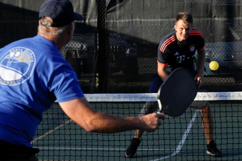 Mike Myers, left, prepares to return a volley against Max Krautter while playing a game of pickleball 