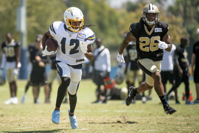 Los Angeles Chargers wide receiver Travis Benjamin, left, sprints with the ball as New Orleans Saints cornerback P.J. Williams chases him during a joint NFL football practice in Costa Mesa, Calif., Thursday, Aug. 15, 2019. (AP Photo/Kyusung Gong)