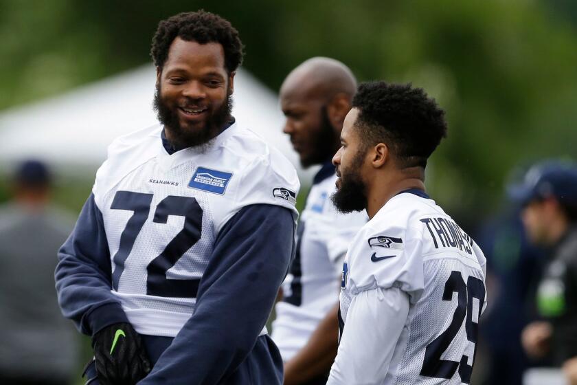 Seattle Seahawks defensive end Michael Bennett, left, talks with free safety Earl Thomas, right, during NFL football practice, Friday, June 13, 2017, in Renton, Wash. (AP Photo/Ted S. Warren)