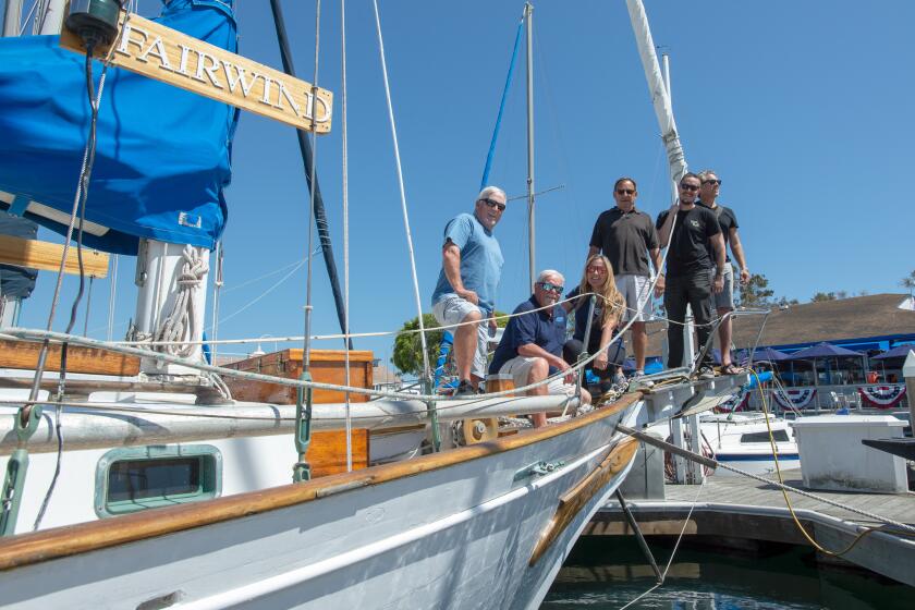 Longtime friends of the late Tim "Skipper" Bercovitz stand aboard his boat, Fairwind, Friday, June 7, in Newport Harbor.