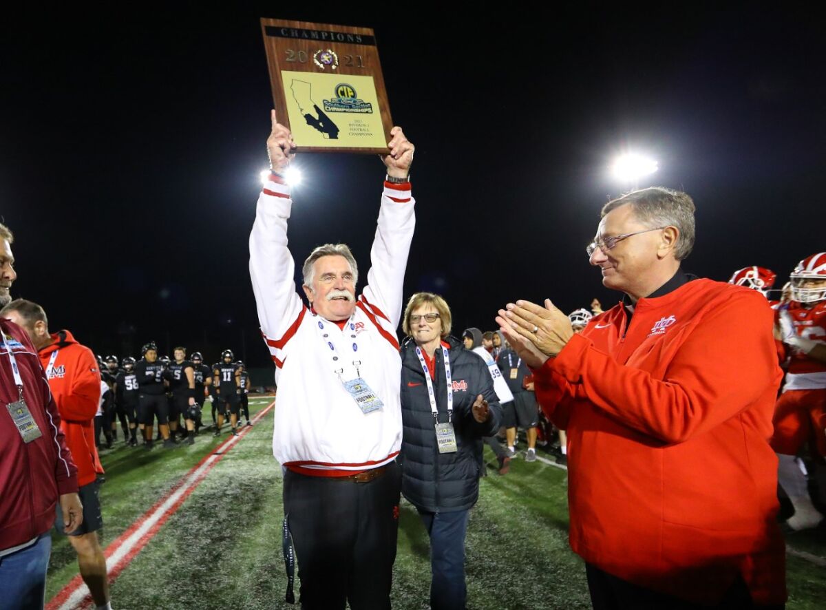 Mater Dei coach Bruce Rollinson holds up the Division 1 title plaque 