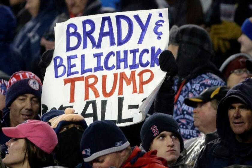 A New England Patriots fan holds a sign referring to Patriots quarterback Tom Brady, Coach Bill Belichick and President Donald Trump during the first half of the AFC championship on Jan. 22.