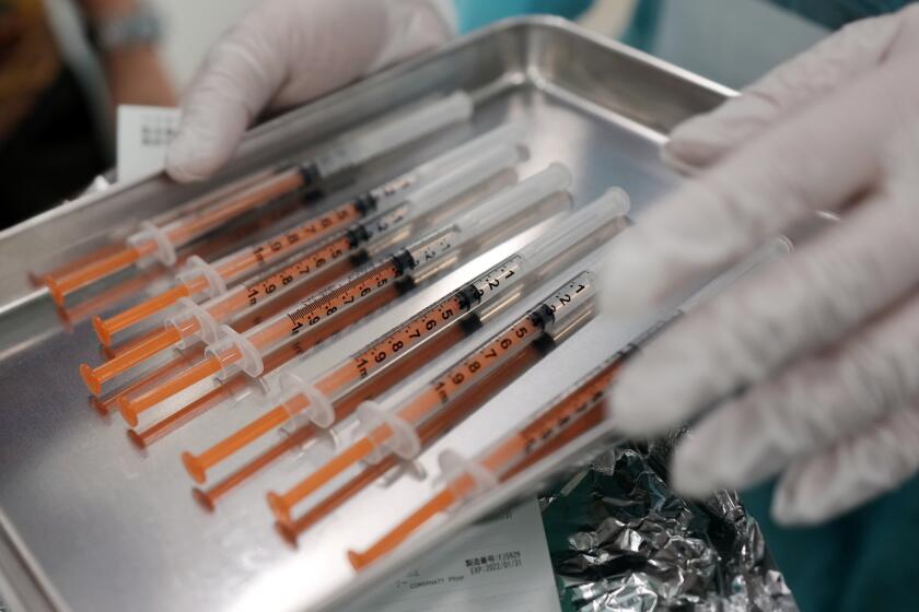 Syringes with the Pfizer vaccine against COVID-19 disease are seen at a vaccination center in the complex of the Tokyo Skytree, the tallest structure in Japan, Thursday, Jan. 6, 2022, in Sumida ward of Tokyo. Before the rollout of third vaccine boosters for the general public, Sumida ward in Tokyo holds a trial run of vaccinating medical workers with booster shots. (AP Photo/Eugene Hoshiko)