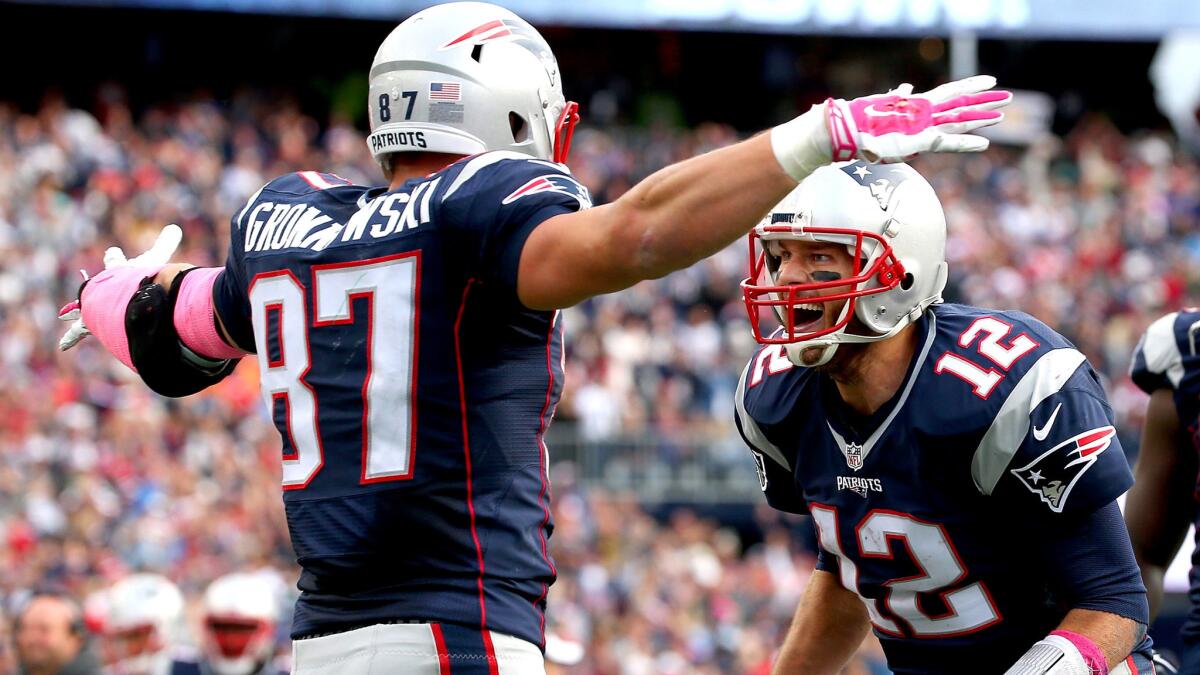 Patriots quarterback Tom Brady (12) and tight end Rob Gronkowski celebrate after what proved to be the winning touchdown pass against the Jets in the fourth quarter Sunday.