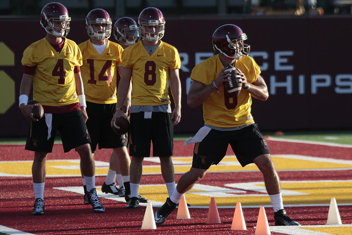 USC quarterback Cody Kessler runs through drills on Aug. 8 as his backups Max Browne (4), Sam Darnold (14) and Ricky Town (8) look on.