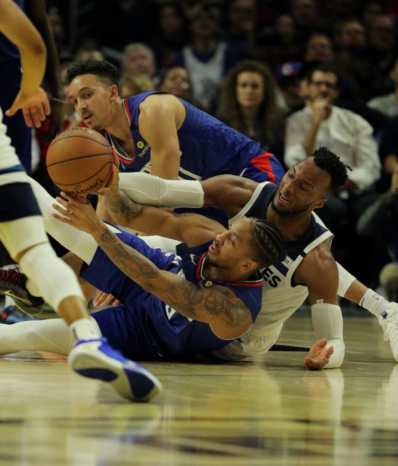 Clippers guard Rodney McGruder recovers a loose ball after a battle with Timberwolves guard Josh Okogie during a game Feb. 1 at Staples Center.