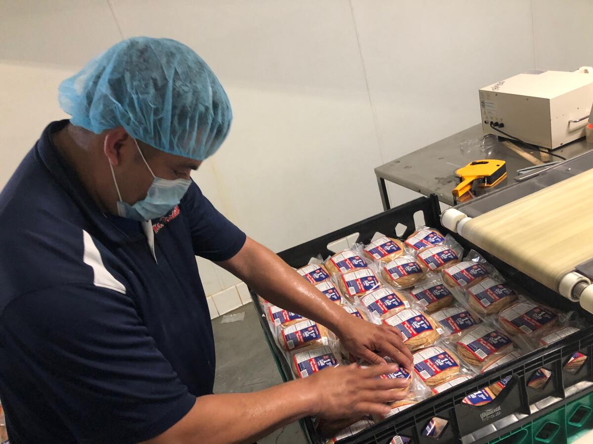 Un empleado organiza los paquetes de tortillas luego de ser embolsados.