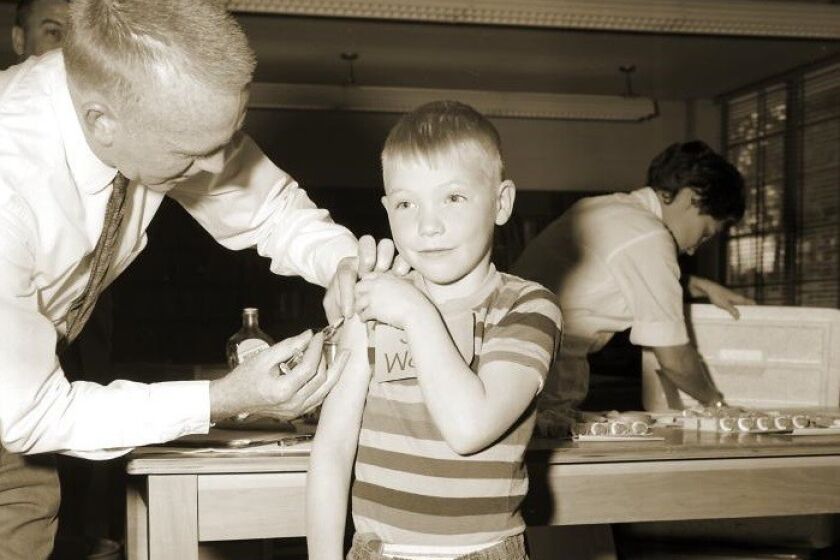 A doctor gives a measles vaccination to a boy at Fernbank School in Atlanta in 1962.