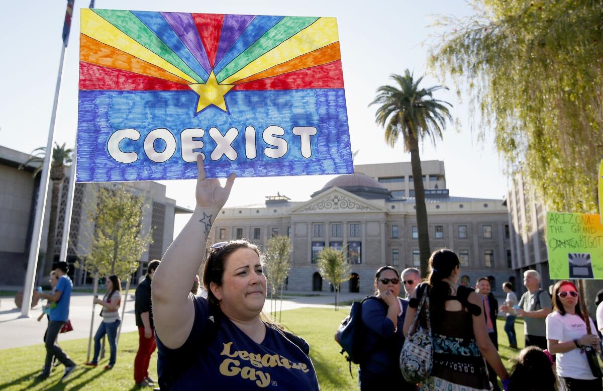 Jo Beaudry joins nearly 250 gay rights supporters protesting SB 1062 Friday in Phoenix. The protesters demanded Gov. Jan Brewer veto legislation that would allow business owners to refuse to serve gays by citing their religious beliefs.