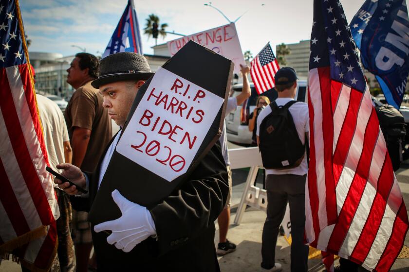 BEVERLY HILLS, CA - OCTOBER 24: Randolph Grant of Culver City holds a coffin that reads R.I.P Harris Biden 2020 at the USA Freedom Rally were hundreds of Trump supporters rallied in Beverly Gardens Park in Beverly Hills on Saturday, Oct. 24, 2020 in Beverly Hills, CA. (Jason Armond / Los Angeles Times)
