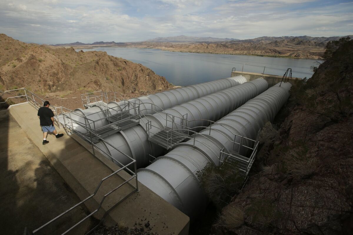 In this Thursday, Oct. 15, 2015 photo, mechanic John Harper walks onto the pipes conveying water pumped from the Colorado River at the Metropolitan Water District of Southern California's Whitsett Intake Pumping Plant near Parker Dam, Calif. The pumping plant is the starting point of the Colorado River Aqueduct.