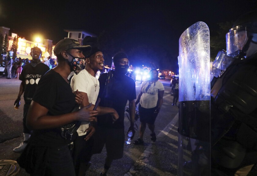 Protesters confront police officers in riot gear on Thursday night, June 24, 2021 in downtown Rock Hill, S.C. Police arrested 11 people on Thursday night as Rock Hill protest continues against controversial police arrest(Tracy Kimball/The Charlotte Observer via AP)