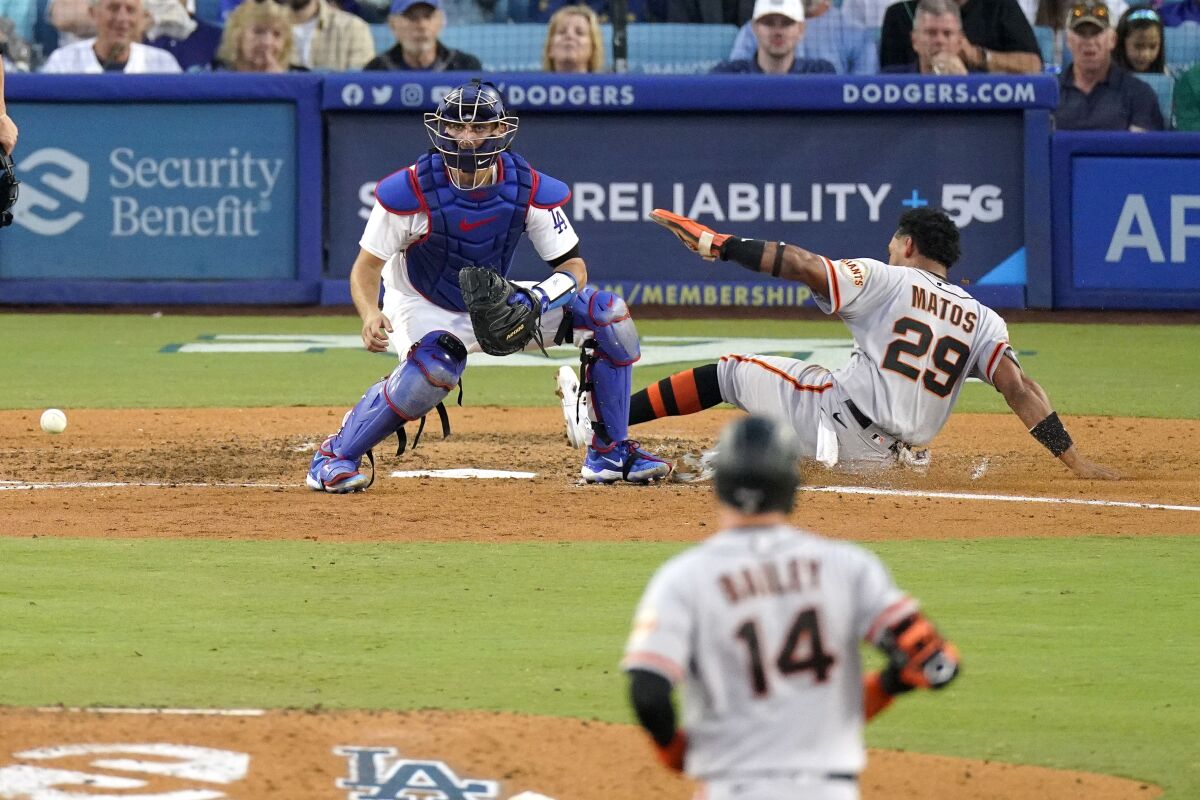 The Giants' Luis Matos scores on a double by Patrick Bailey as Dodgers catcher Austin Barnes takes a late throw.
