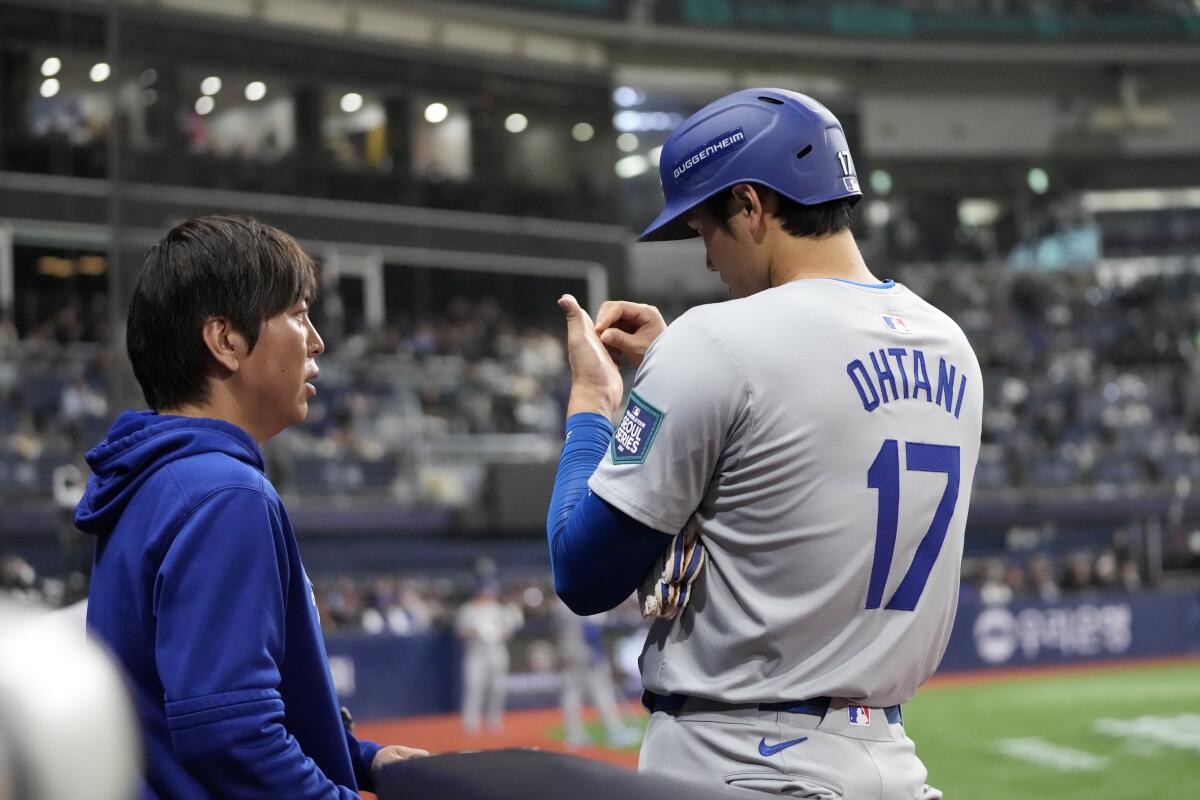 Shohei Ohtani talks to interpreter Ippei Mizuhara during a game