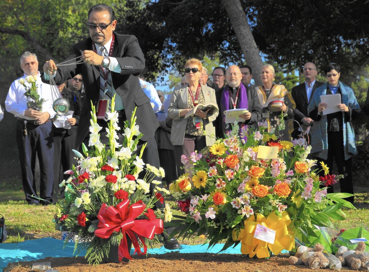 L.A. County-USC Medical Center intern chaplain Manuel Luis Torres swings an incense burner over a grave during a multi-faith ceremony remembering 1,489 individuals left unclaimed at the L.A. County Cemetery in Boyle Heights. The county has been conducting the burials since 1896.