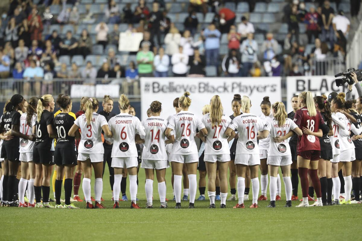 Washington Spirit and NJ/NY Gotham FC players cause a stoppage midway through the first half and gather in unity for U.S. women's team players, during an NWSL soccer match Wednesday, Oct. 6, 2021, in Chester, Pa. (Charles Fox/The Philadelphia Inquirer via AP)