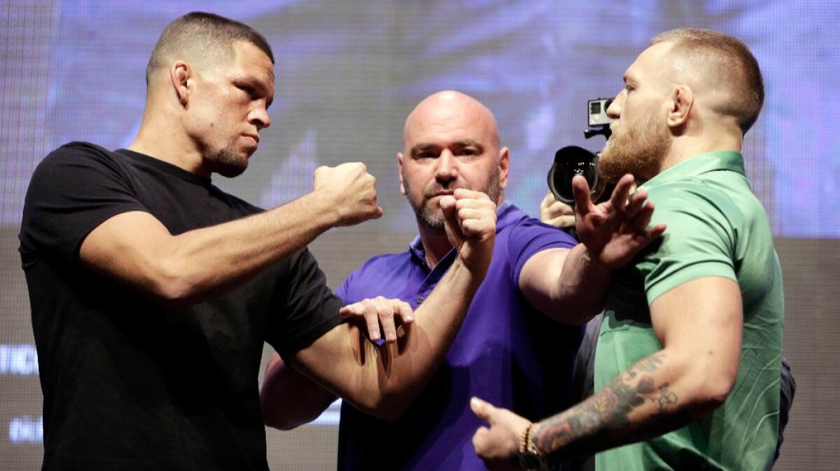 Nate Diaz and Conor McGregor, right, are separated by UFC President Dana White during a news conference on July 7.