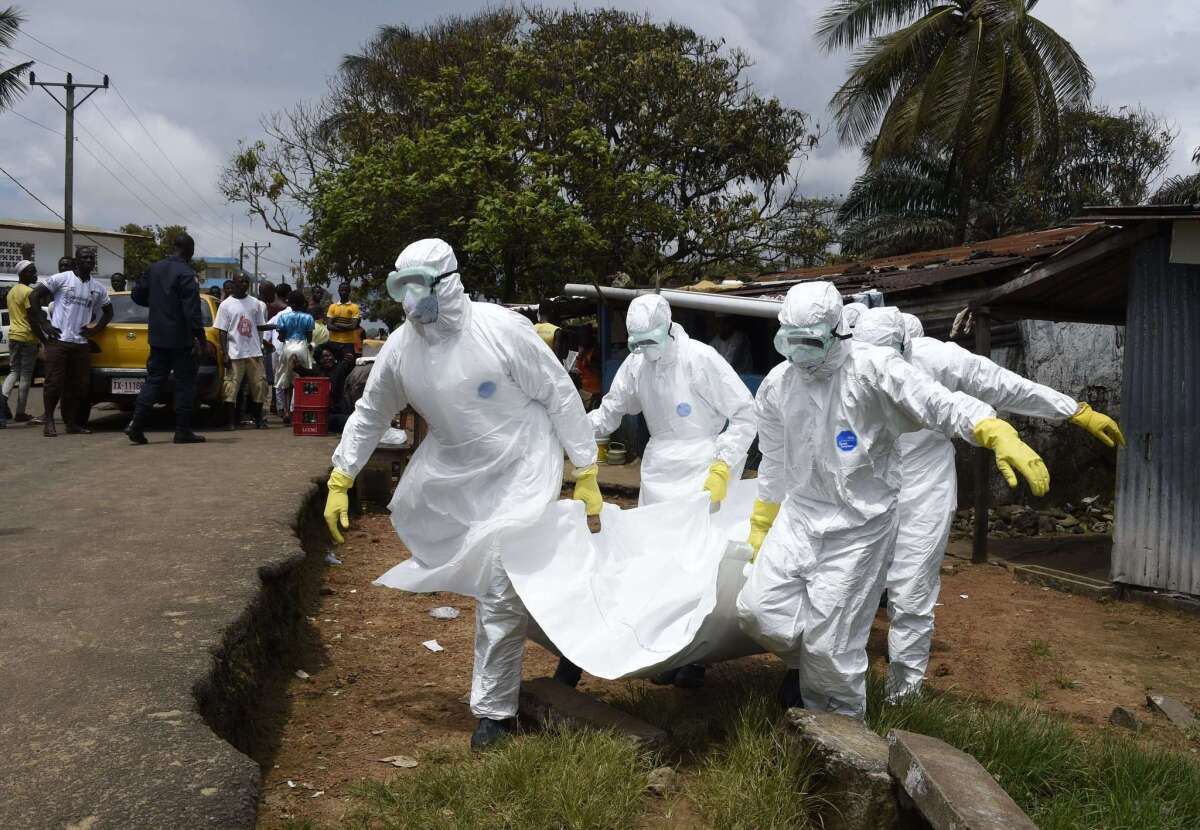 Red Cross workers carry away the body of a suspected Ebola victim in Monrovia, the capital of Liberia.