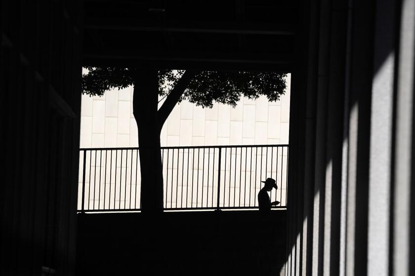 FILE - A person is silhouetted against a wall as they look down at their cell phone outside the Clara Shortridge Foltz Criminal Justice Center on July 29, 2021, in Los Angeles. With abortion now or soon to be illegal in over a dozen states and severely restricted in many more, Big Tech companies that vacuum up personal details of their users are facing new calls to limit that tracking and surveillance. One fear is that law enforcement or vigilantes could use those data troves against people seeking ways to end unwanted pregnancies. (AP Photo/Chris Pizzello, File)