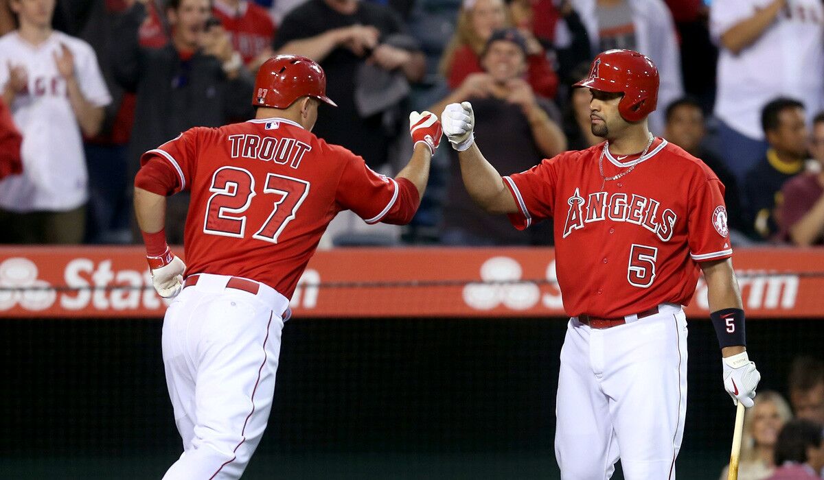 Angels center fielder Mike Trout is congratulated by first baseman Albert Pujols (5) after hitting a solo home run against the Angels in the third inning Friday night in Anaheim.