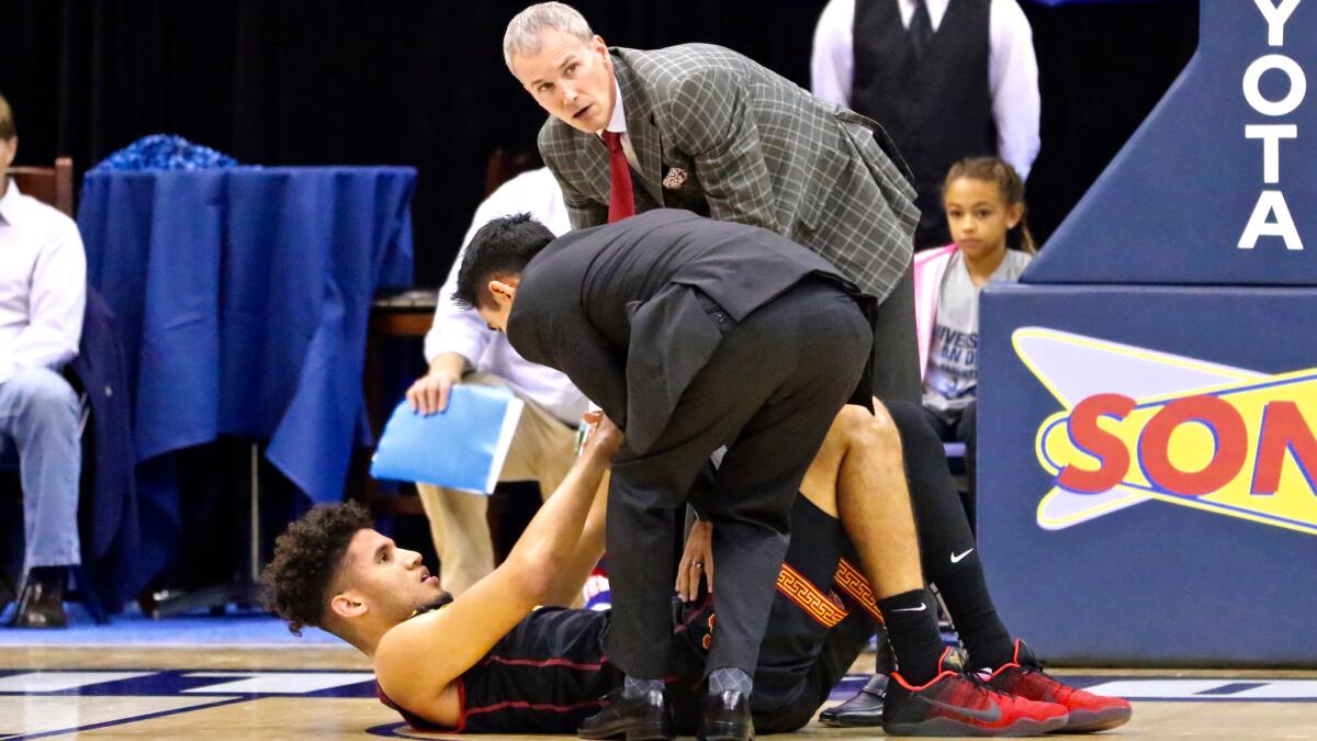 USC forward Bennie Boatwright talks to trainer Jon Yonamine and Coach Andy Enfield after he was injured during the game against San Diego on Wednesday night.