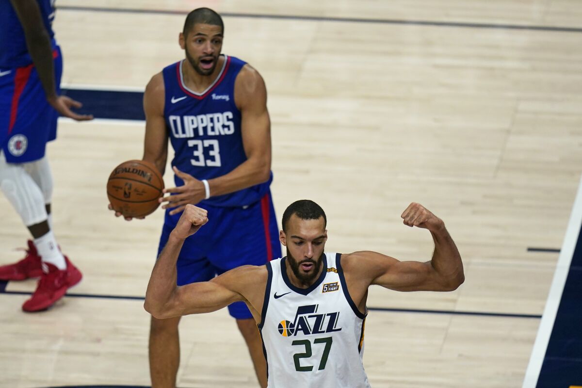 Utah Jazz center Rudy Gobert (27) flexes his muscles after scoring against Los Angeles Clippers' Nicolas Batum (33) during the second half of an NBA basketball game Friday, Jan. 1, 2021, in Salt Lake City. (AP Photo/Rick Bowmer)