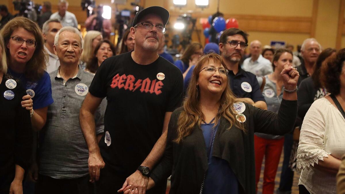 Supporters react as early returns show Democrat Jon Ossoff leading in a special election for a House seat in the Atlanta suburbs.