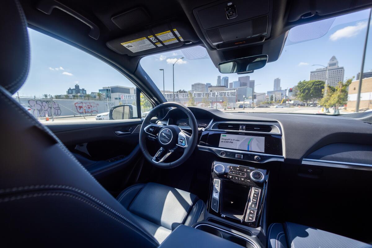 A Waymo robotaxi Jaguar I-PACEs driverless car drives around downtown Los Angeles 