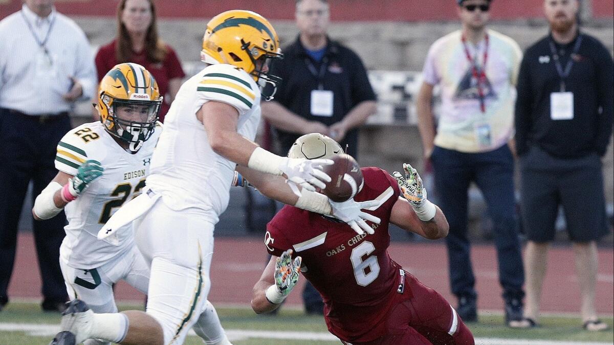 Edison High linebacker Cameron Eden gets his hands on the ball to knock it into the air and intercept it in a nonleague football game at Oaks Christian High on Friday.