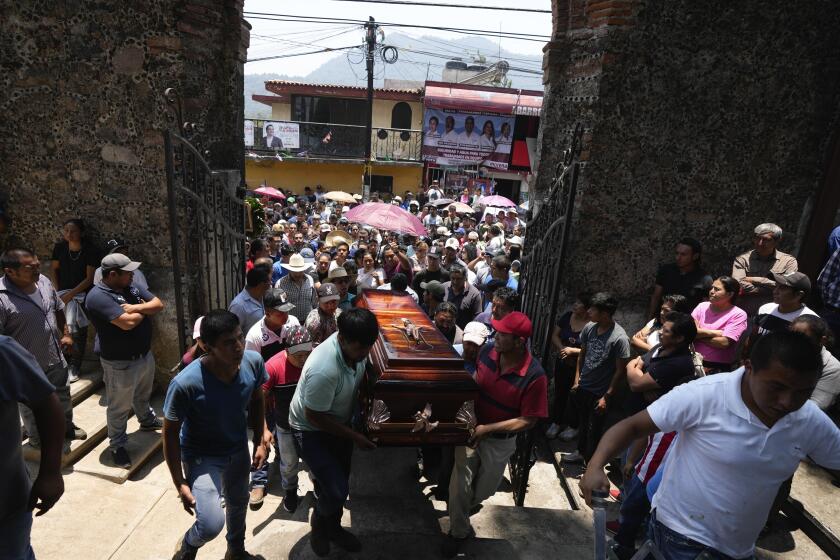 Parientes y amigos introducen a una iglesia el ataúd con los restos de un hombre asesinado en una masacre para una misa fúnebre en su honor, el martes 14 de mayo de 2024, en Huitzilac, México. (AP Foto/Fernando Llano)