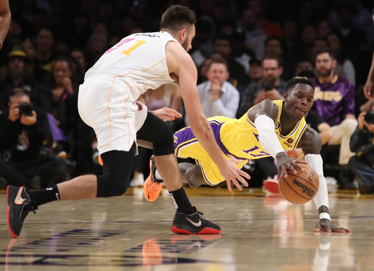 Lakers guard Dennis Schroder battles Miami Heat guard Max Strus for a loose ball.