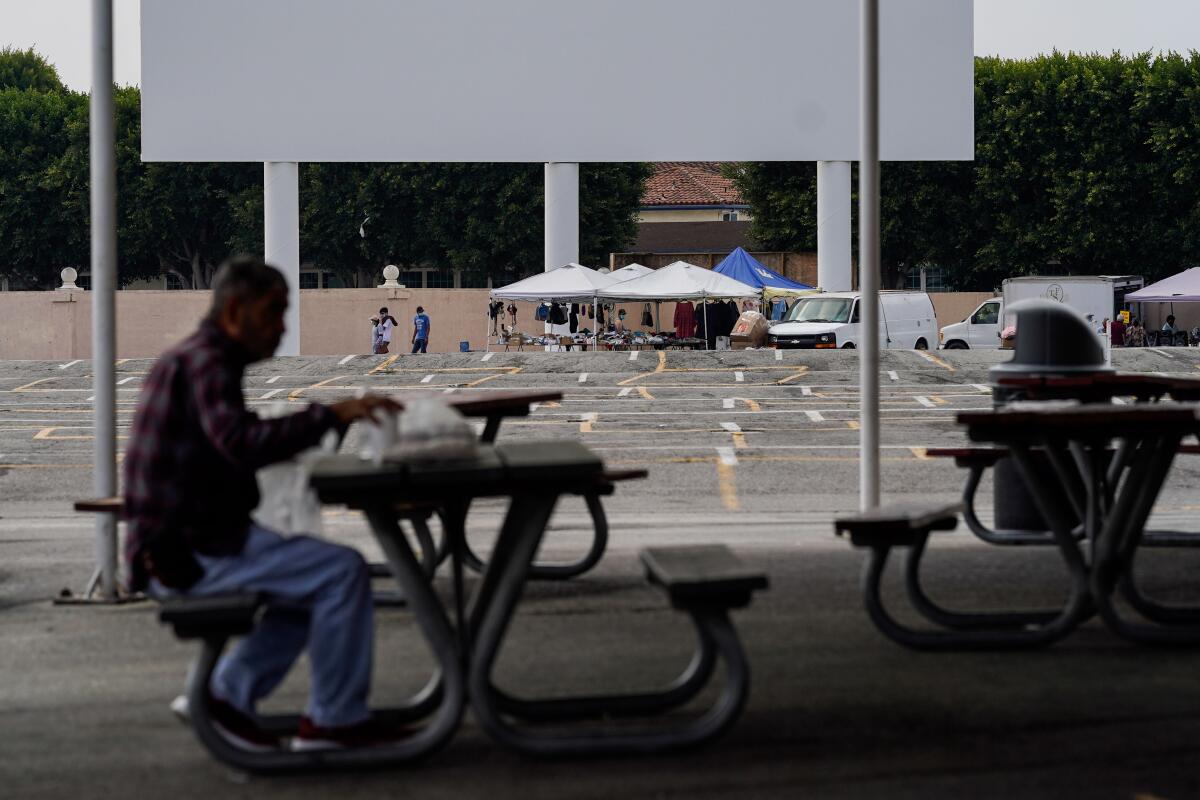 A lone vendor is seen near the Drive-in screen at the Paramount Swap Meet