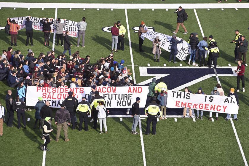 Demonstrators stage a climate change protest at the Yale Bowl delaying the start of the second half of an NCAA college football game between Harvard and Yale Saturday, Nov. 23, 2019, in in New Haven, Conn. (Arnold Gold/New Haven Register via AP)