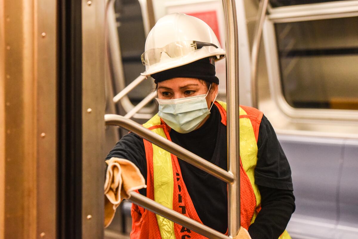 A cleaning crew member disinfects a New York City subway train on May 4, 2020.