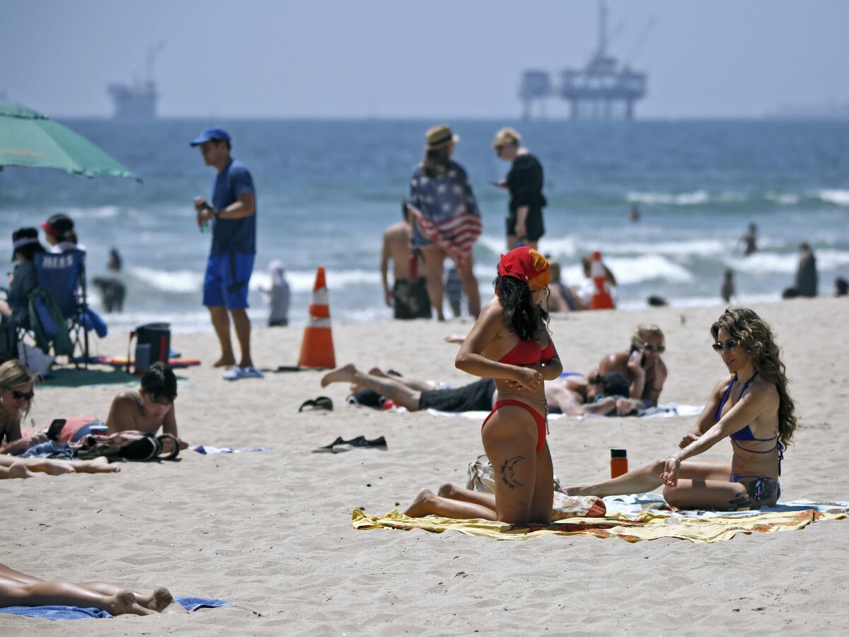 Beachgoers sunbathing near the Huntington Beach Pier.
