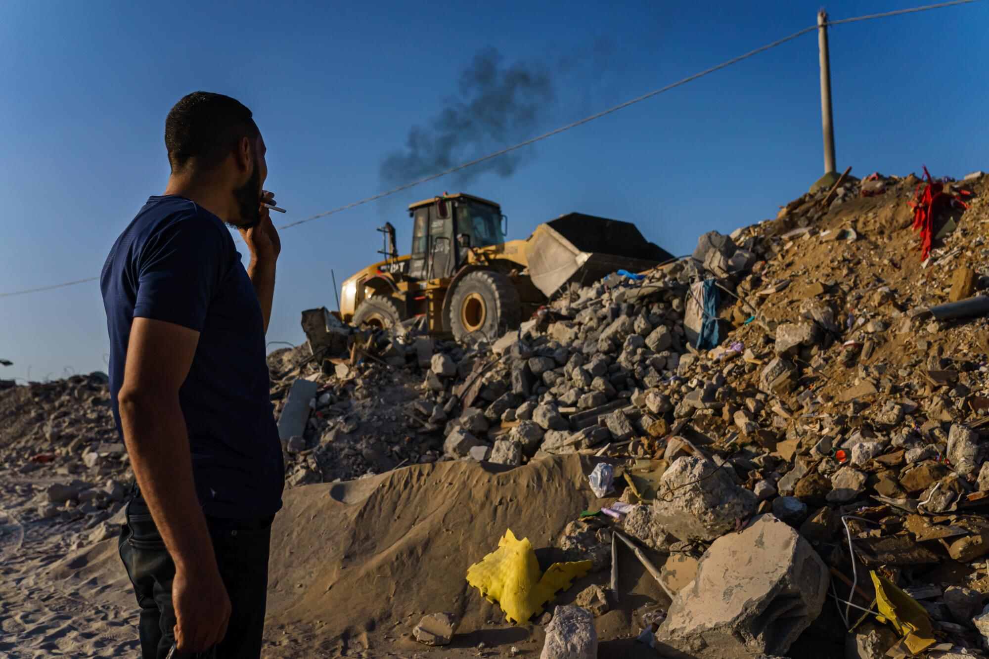 A bulldozer pushes through rubble 