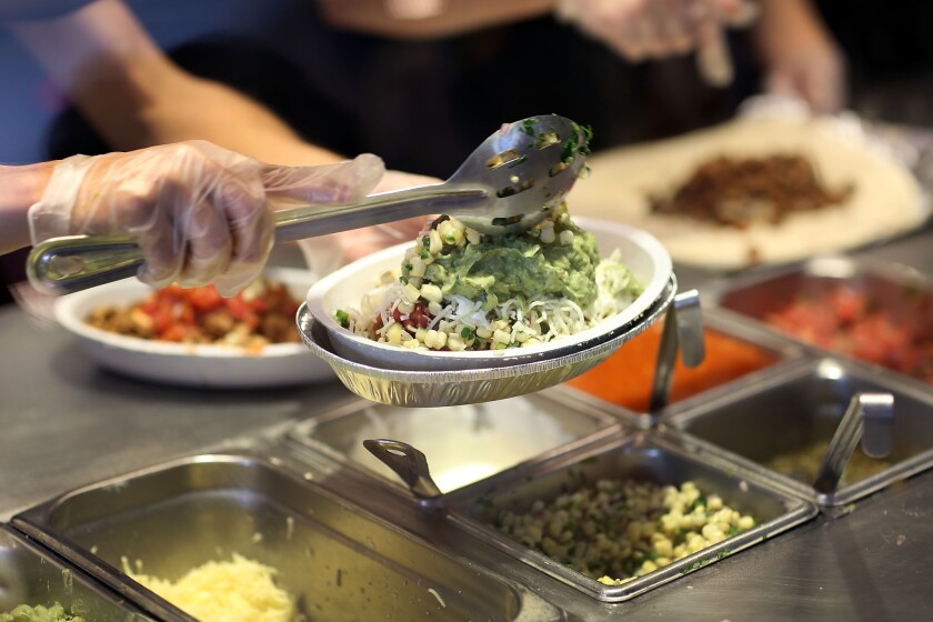 Chipotle restaurant workers in Miami fill orders for customers on April 27, the day that the company announced it will use only non-GMO ingredients in its food.