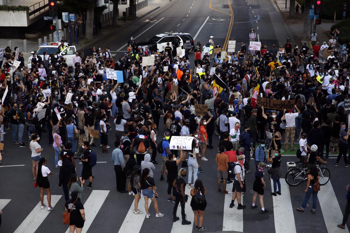 An overhead view of people standing in the middle of an intersection during a Black Lives Matter protest 