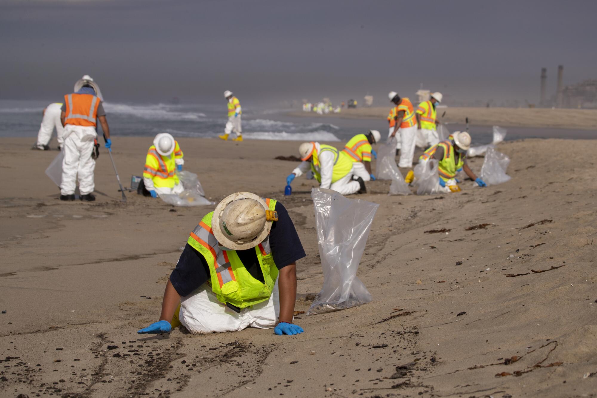 Cleanup crews mop up oil on the sand at Huntington State Beach.