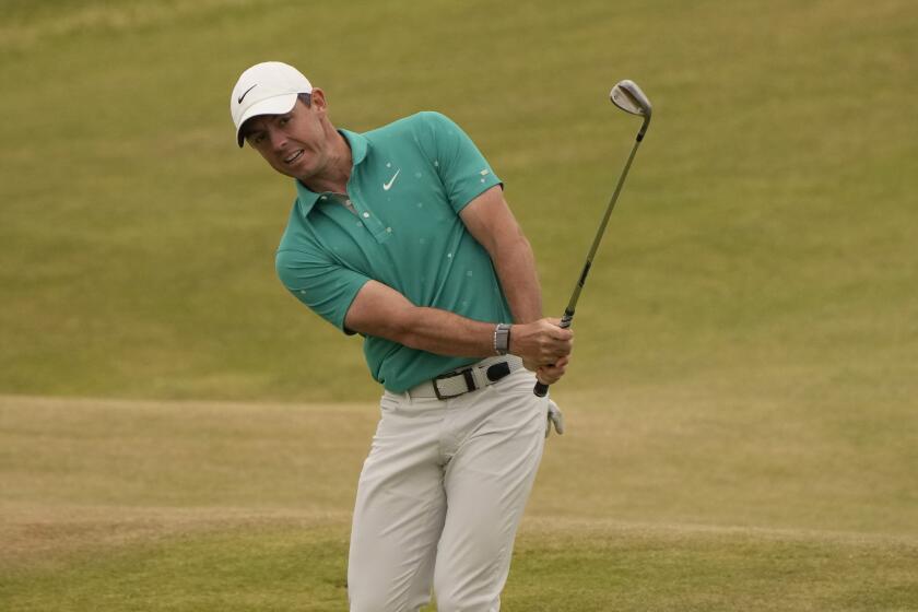 Rory McIlroy of Northern Ireland hits onto the 11th green during the third round.