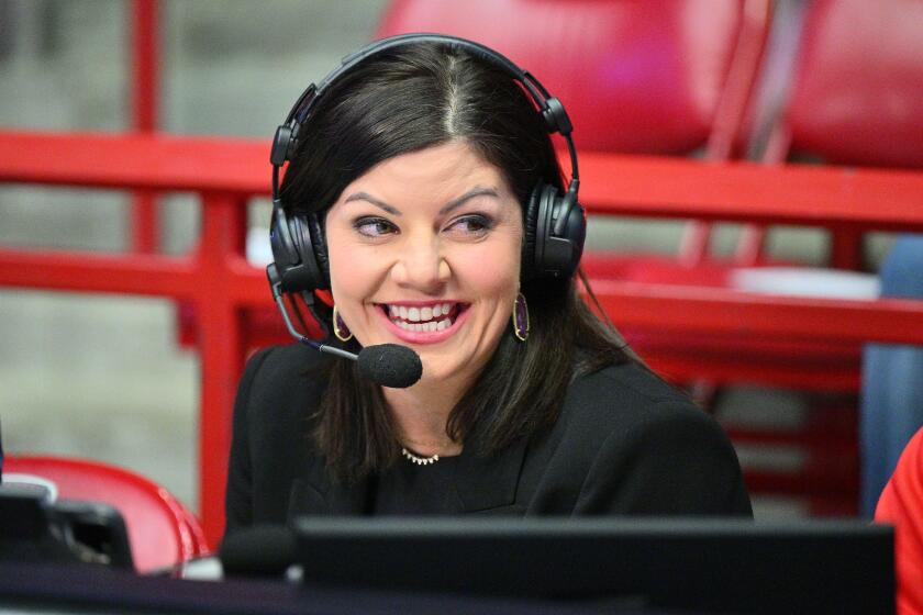 Play-by-play announcer Jenny Cavnar wears a headset before broadcasting a college basketball game.