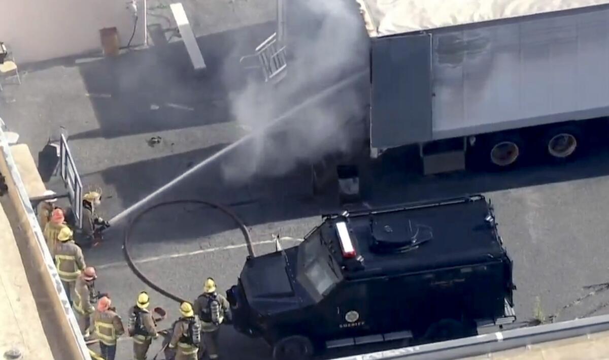 Fire crews try to suppress a fire inside a trailer at the Pitchess Detention Center in Castaic.