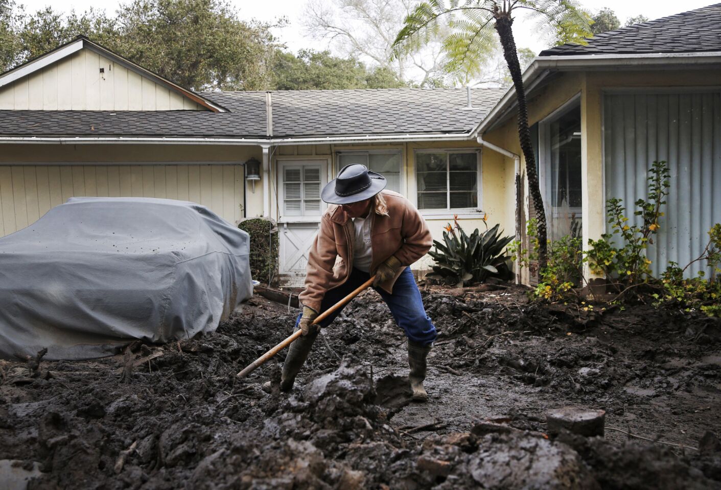 Mark Vance shovels mud away from his house on Olive Mill Road in Montecito, California.