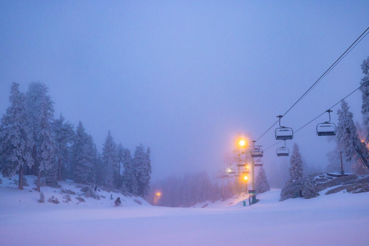 Snow falls on a ski lift.