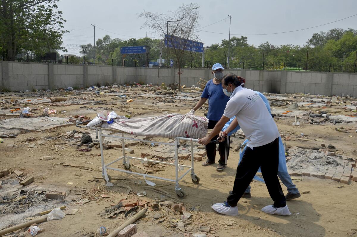 Body of a COVID-19 victim is wheeled in a ground that has been converted into a crematorium in New Delhi, India, Saturday, May 1, 2021. India on Saturday set yet another daily global record with 401,993 new cases, taking its tally to more than 19.1 million. Another 3,523 people died in the past 24 hours, raising the overall fatalities to 211,853, according to the Health Ministry. Experts believe both figures are an undercount. (AP Photo/Amit Sharma)