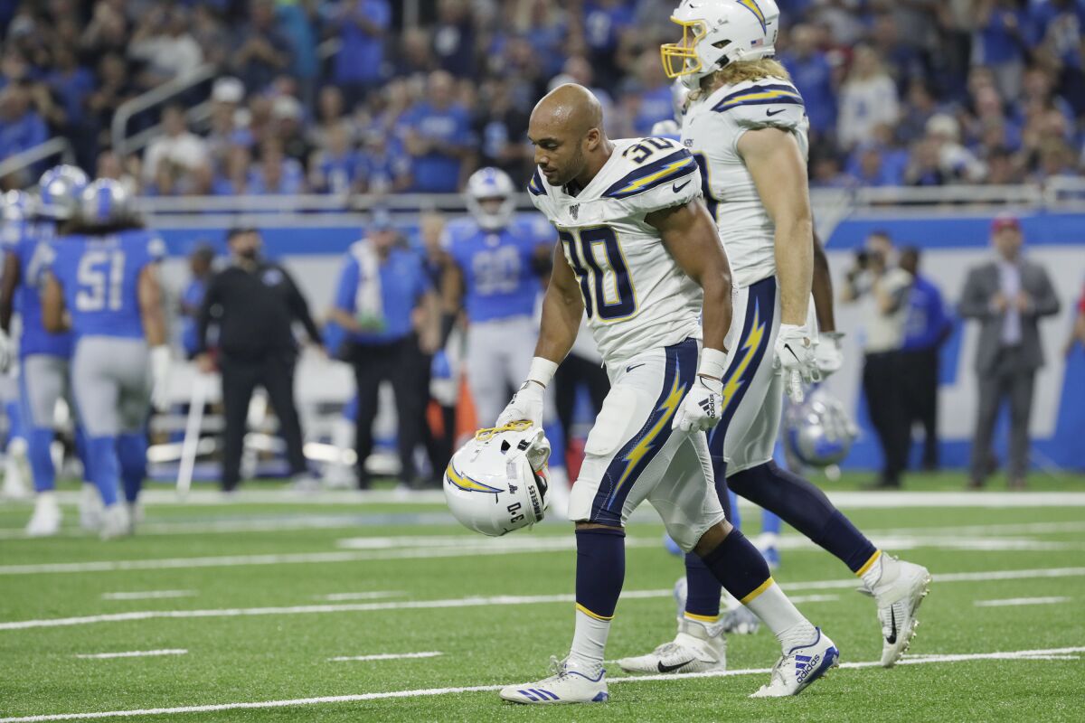 Chargers running back Austin Ekeler walks off the field after fumbling at the goal line during the third quarter of a 13-10 loss to the Detroit Lions on Sunday.